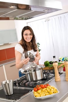 Cooking - Young woman with spaghetti on stove