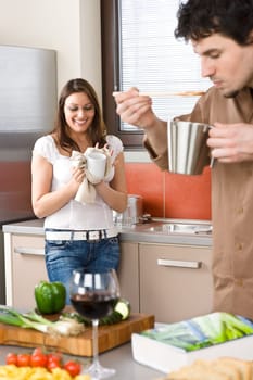 Happy couple in modern kitchen cooking