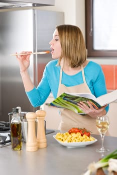 Cooking - Woman tasting Italian tomato sauce in modern kitchen