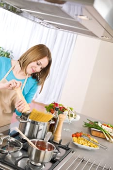 Cooking - Young woman with spaghetti on stove