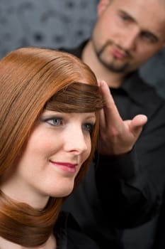 Professional hairdresser with fashion model at luxury salon