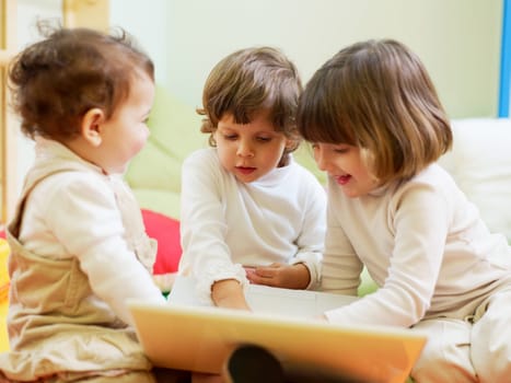 three little girls and female teacher in kindergarten
