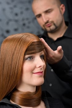 Professional hairdresser with fashion model at luxury salon