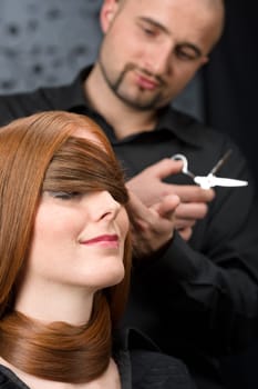 Professional hairdresser with fashion model at luxury salon