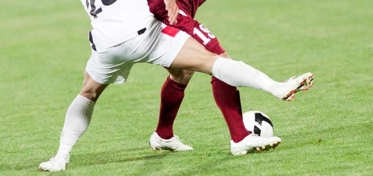 Soccer players fighting for the ball