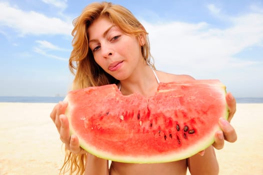 Woman eating watermelon on the beach