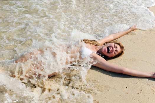 woman in bikini lying in the sand on the beach