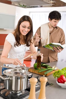 Happy couple in modern kitchen cooking