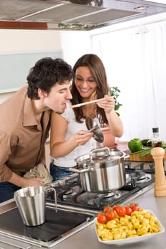 Couple cook in kitchen - man taste food