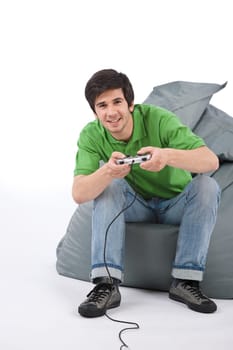 Young happy man playing video game with control pad