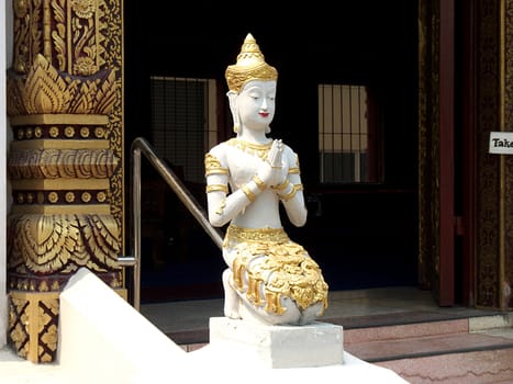 Praying figure in front of a temple