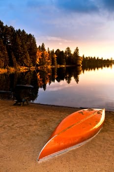 Lake sunset with canoe on beach