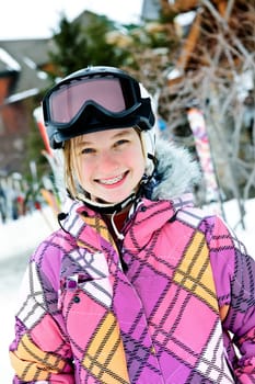 Happy girl in ski helmet at winter resort