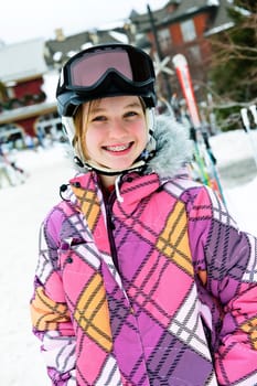 Happy girl in ski helmet at winter resort