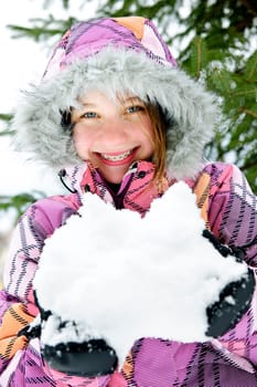Happy winter girl holding snow