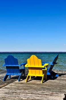 Chairs on wooden dock at lake
