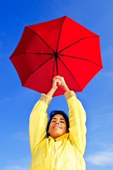 Beautiful young woman in raincoat with umbrella