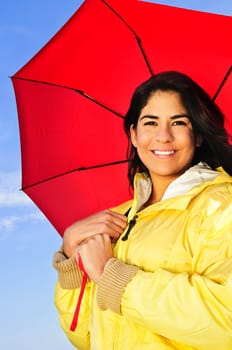 Beautiful young woman in raincoat with umbrella