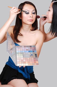 Two Chinese girls doing makeup.