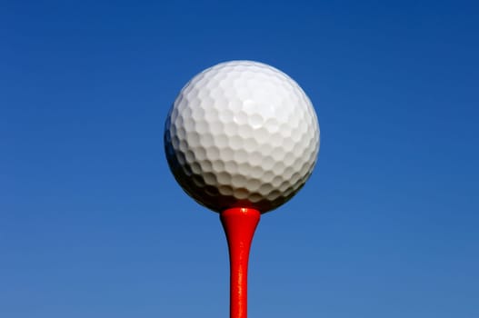 White Golf Ball on Red Tee