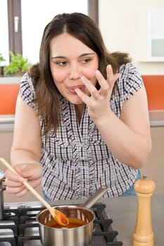 Cook - plus size woman tasting Italian tomato sauce