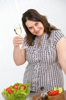 Cook - Plus size happy woman preparing salad in kitchen