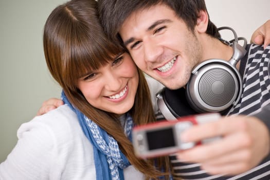 Students - happy teenage couple taking photo with camera