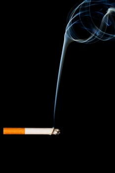 burning cigarette in front of black