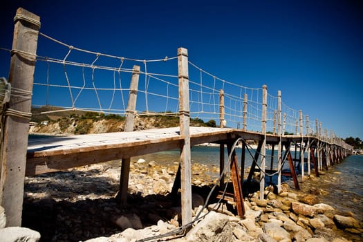 wooden bridge with ropes over a river in zakhyntos
