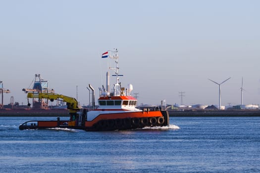 Tugboat with crane passing by on the river