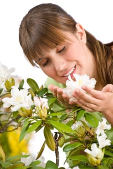 Portrait of woman smelling blossom of Rhododendron flower