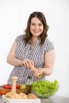 Cook - Plus size happy woman preparing salad in kitchen