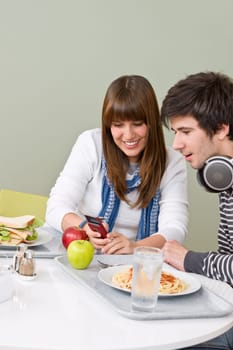 Student cafeteria - teenage couple with mobile phone
