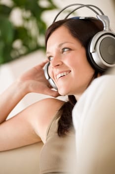 Woman with headphones listen to music in lounge
