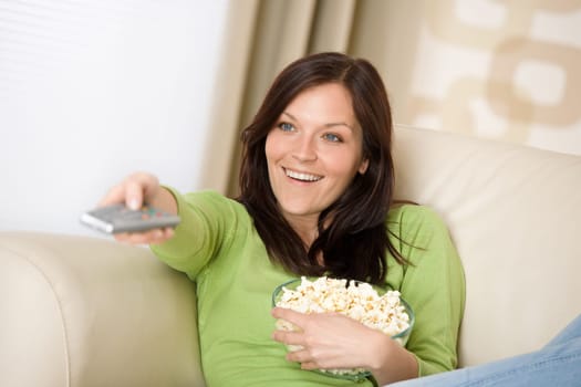 Woman pointing with television remote control
