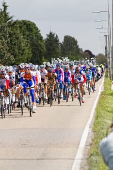 Competitors and following teams in the Giro dItalia passing by on a polderroad i