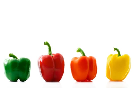 Four colored peppers in a row