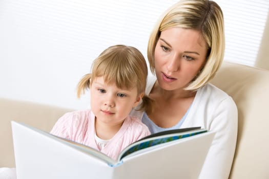 Mother with little girl read book