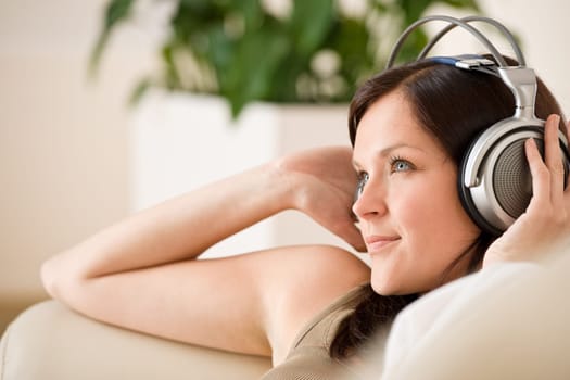 Smiling woman with headphones  listen to music in lounge