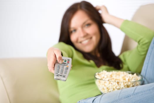 Woman watching television with popcorn in living room
