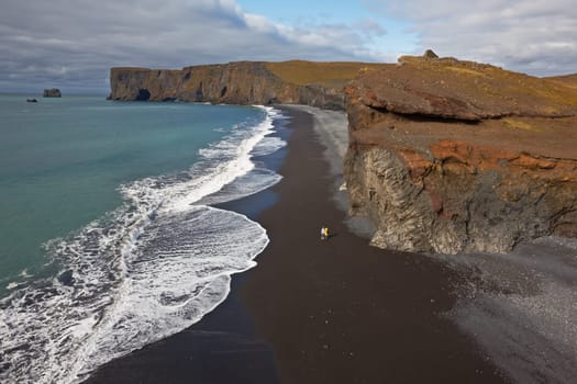 Black sand beach with Lundadrangur Rock Arch in Dyrholaey, South