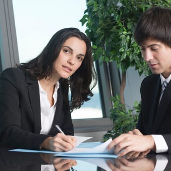 Businesswoman signs paperwork