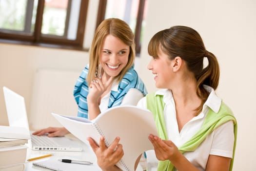 Student at home - two woman with book and laptop