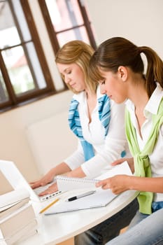 Student at home - two woman with book and laptop