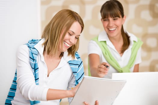 Student at home - two woman with book and laptop