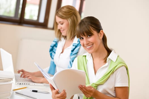 Student at home - two woman with book and laptop
