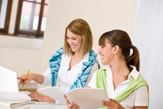 Student at home - two woman with book and laptop