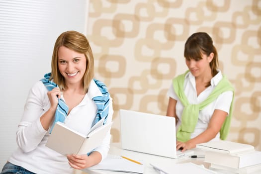 Student at home - two woman with book and laptop
