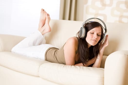 Smiling woman with headphones  listen to music in lounge