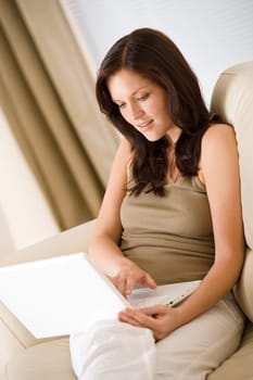 Young woman with laptop on sofa home in living room